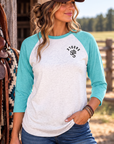 The Brand Baseball Tee in Tahiti Blue/Heather White — female model, front view