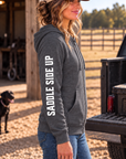 The Branded Zip in Heathered Charcoal — female model, side view showing SADDLE SIDE UP sleeve print