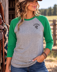 The Brand Baseball Tee in Envy/Premium Heather — female model, front view