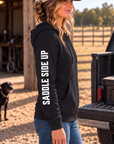 The Branded Zip in Black — female model, side view showing SADDLE SIDE UP sleeve print